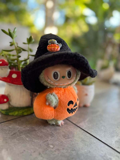 Disfraz Labubu Halloween 🎃 Calabaza y Sombrero de Bruja con Labubu en un sombrero negro y disfraz naranja.